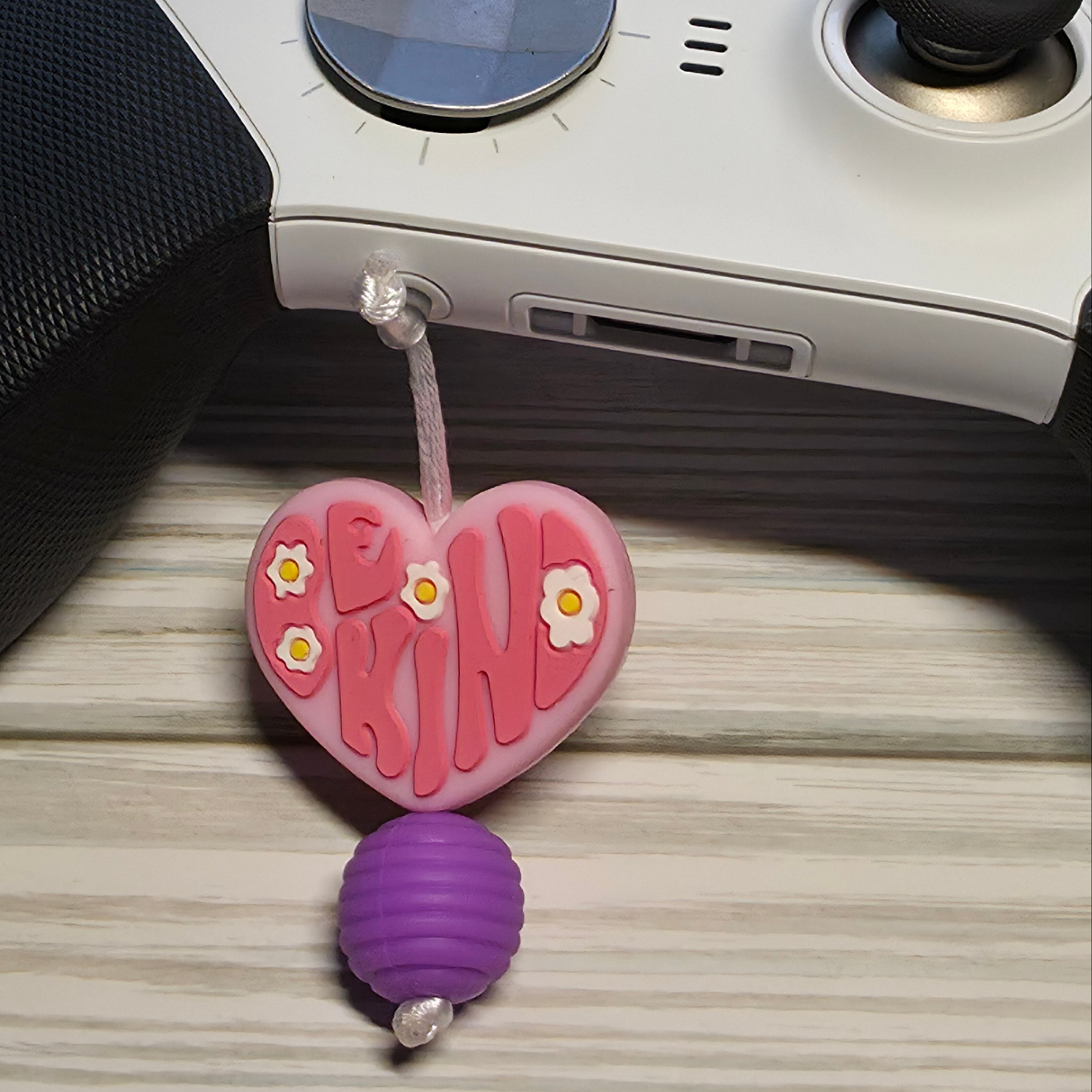 Handmade silicone Nintendo Switch charms in various colors and shapes, attached with white silky cords – designed to add charm without scratching the console.
