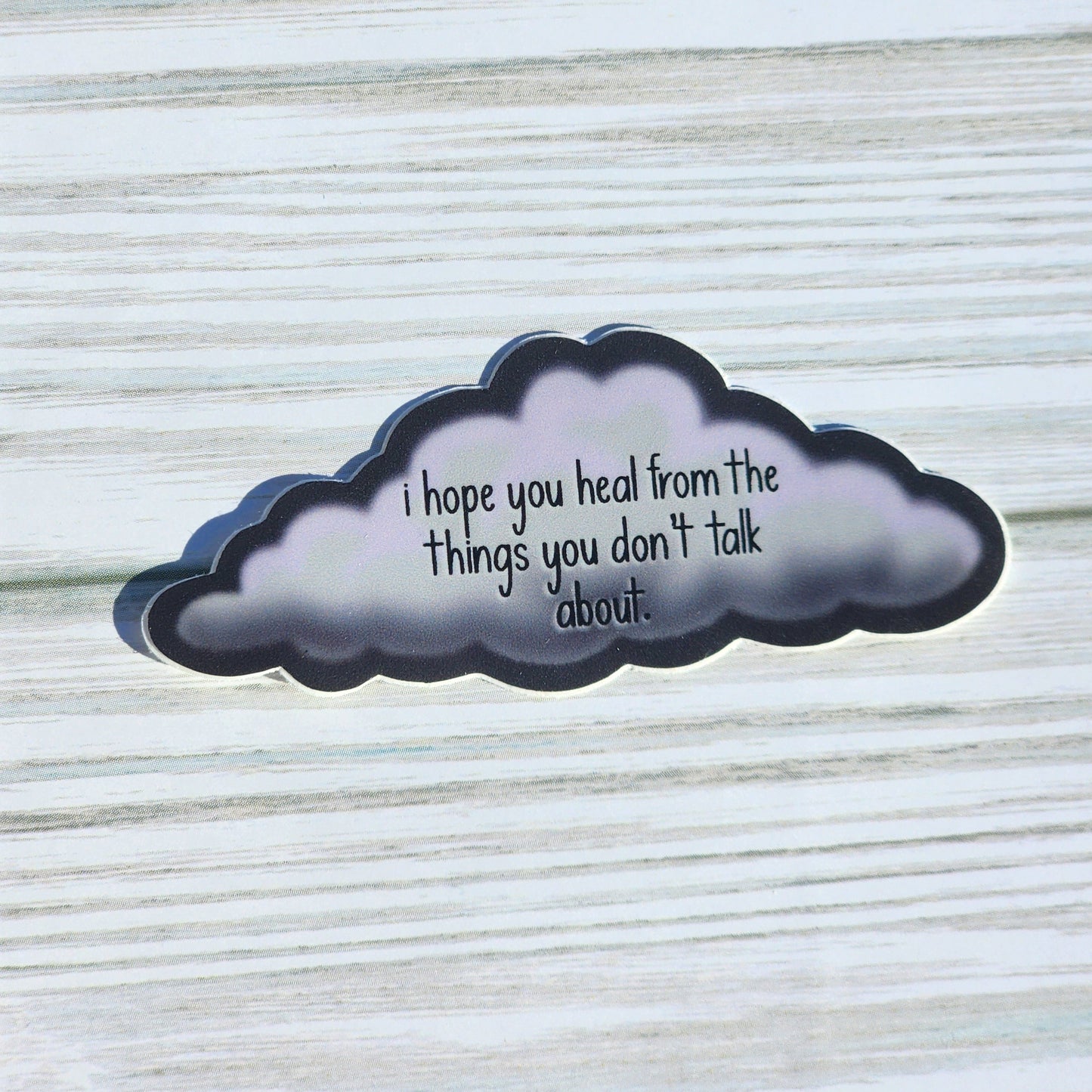 Sticker in the shape of a cloud with gentle lettering: 'I hope you heal from the things you don’t talk about'