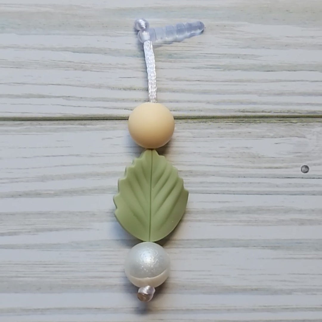 Handmade silicone Nintendo Switch charms in various colors and shapes, attached with white silky cords – designed to add charm without scratching the console.