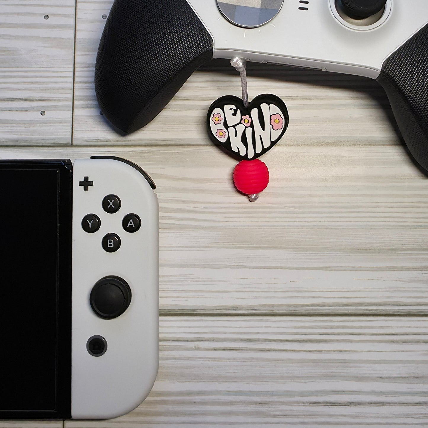 Handmade silicone Nintendo Switch charms in various colors and shapes, attached with white silky cords – designed to add charm without scratching the console.