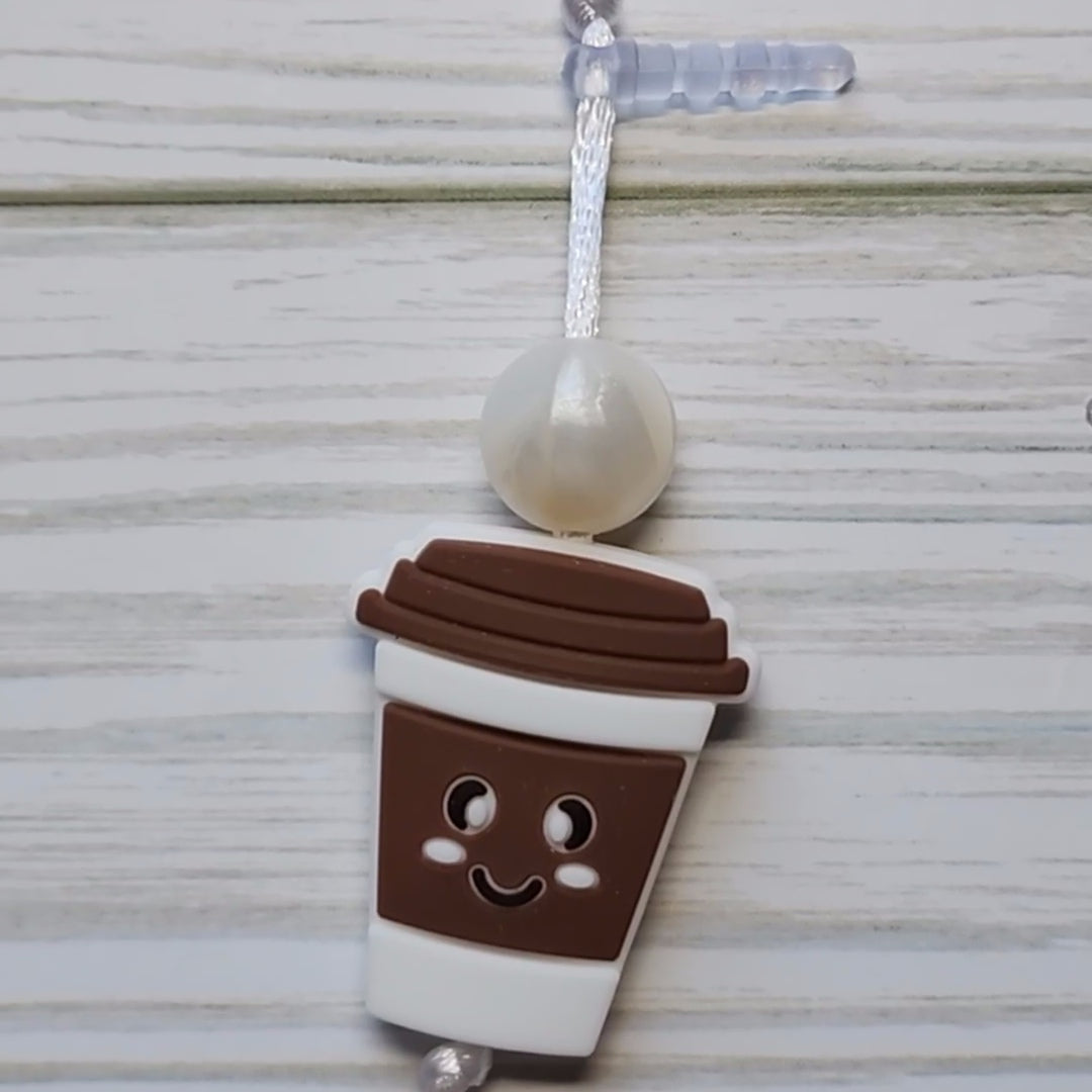 Handmade silicone Nintendo Switch charms in various colors and shapes, attached with white silky cords – designed to add charm without scratching the console.