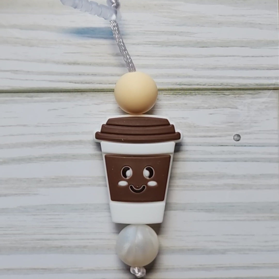 Handmade silicone Nintendo Switch charms in various colors and shapes, attached with white silky cords – designed to add charm without scratching the console.