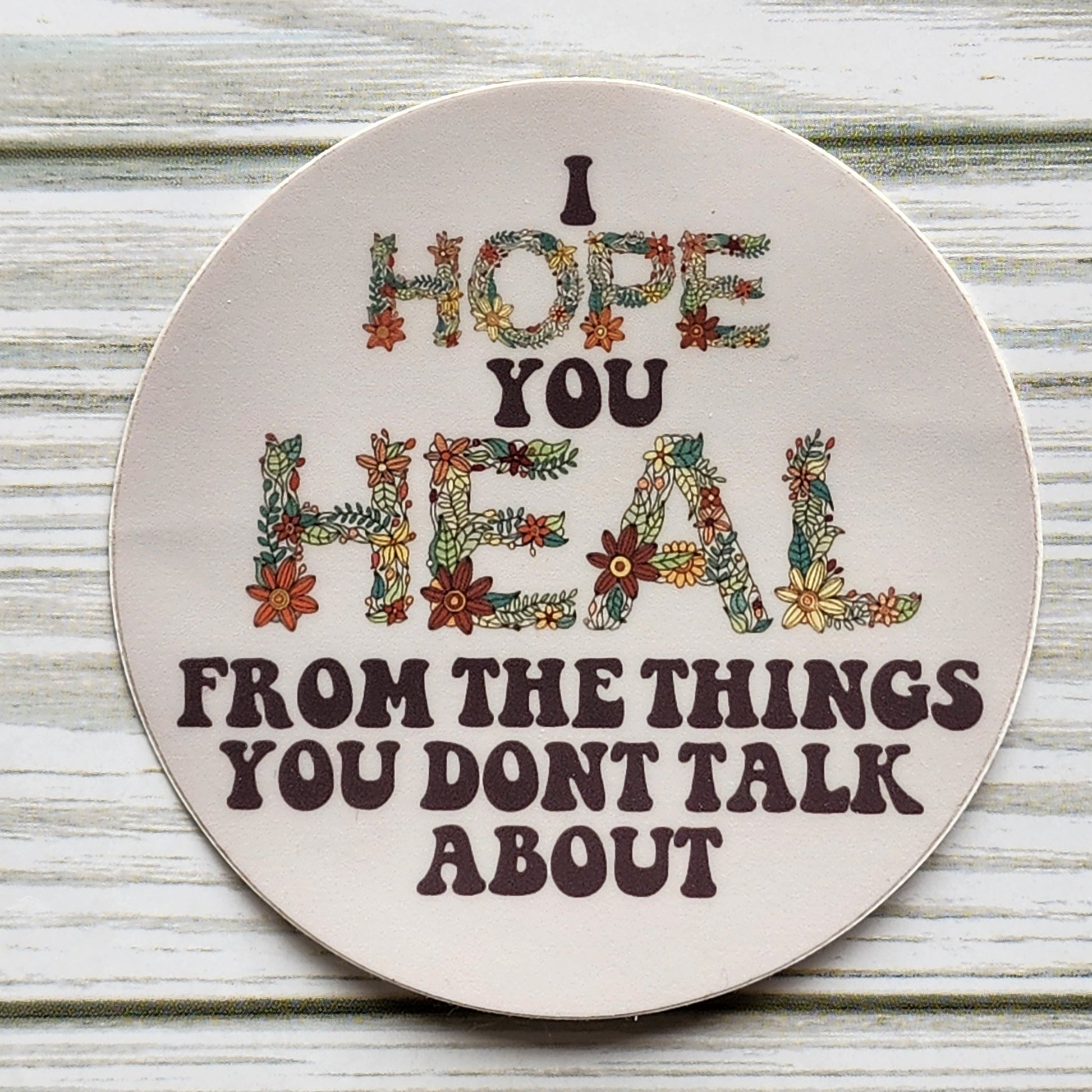 I Hope You Heal From The Things You Don't Talk About Circle Sticker with the words Hope and Heal made out of a hand drawn floral design in the shape of each letter. 