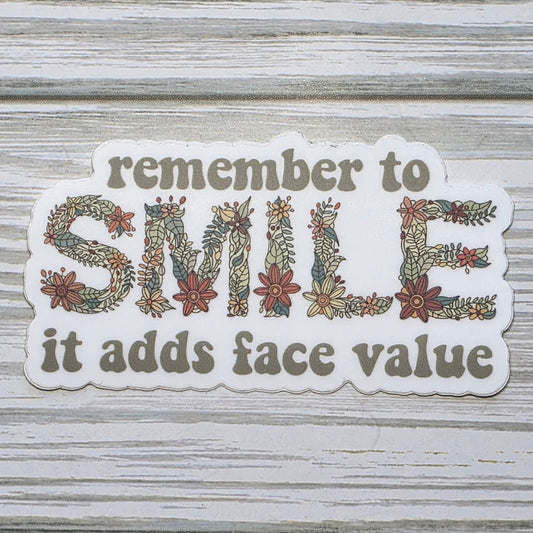 Typography design reading ‘Remember to Smile It Adds Face Value,’ with the word ‘Smile’ in decorative floral lettering.
