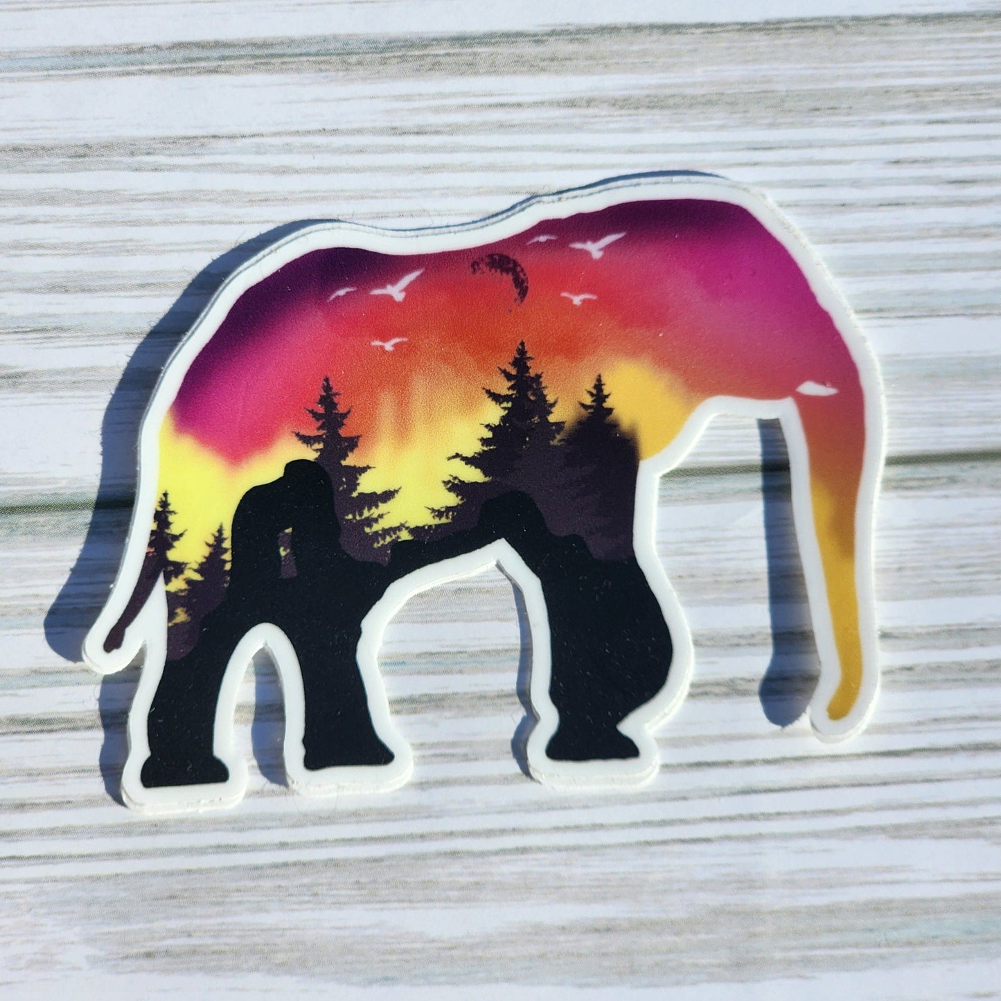 Sunset desert landscape within the silhouette of an elephant – shadows of red rocks, moon, and birds form the natural coloring of the design.